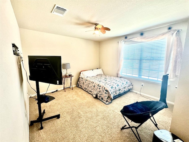 carpeted bedroom with a textured ceiling and ceiling fan