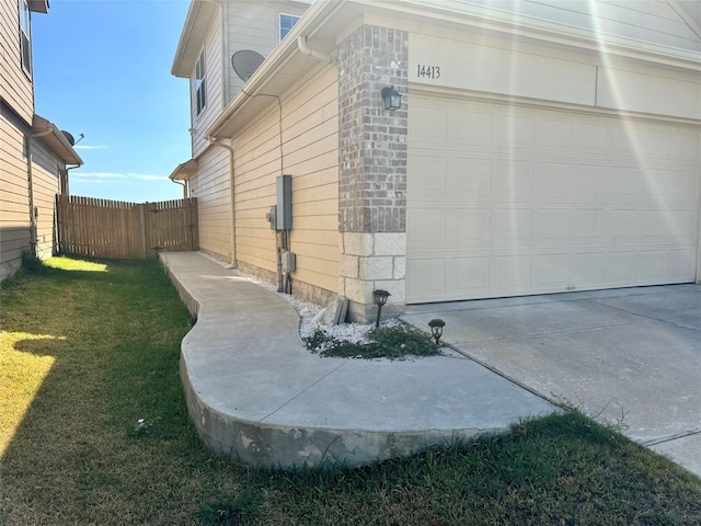 view of property exterior featuring a yard and a garage