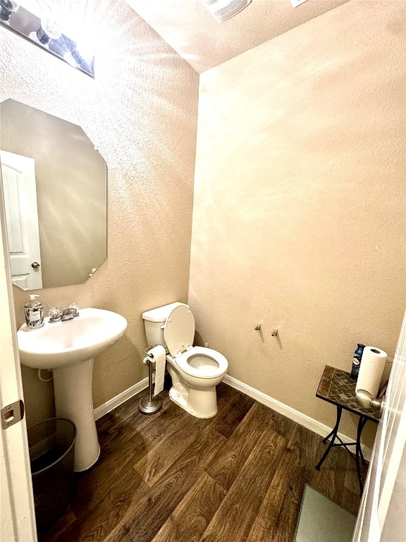 bathroom with toilet, hardwood / wood-style flooring, and sink