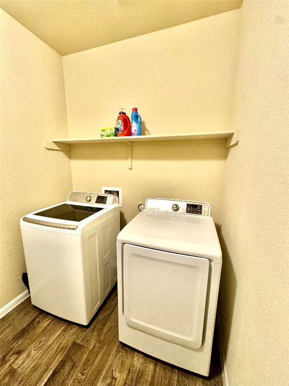 laundry room with a textured ceiling, washer and dryer, and dark hardwood / wood-style floors