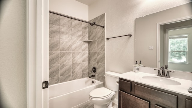 full bathroom with vanity, tiled shower / bath combo, and toilet