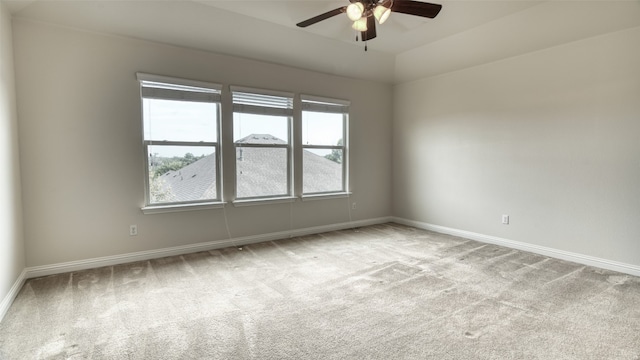 carpeted empty room with ceiling fan, lofted ceiling, and a wealth of natural light