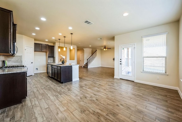 kitchen with recessed lighting, open floor plan, light wood finished floors, and dark brown cabinets