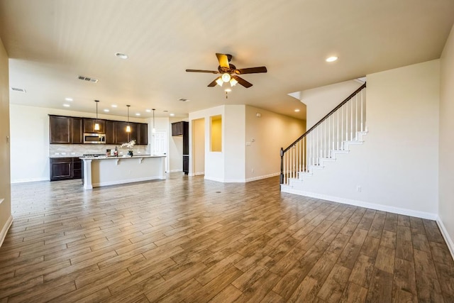 unfurnished living room with visible vents, a ceiling fan, wood finished floors, recessed lighting, and baseboards