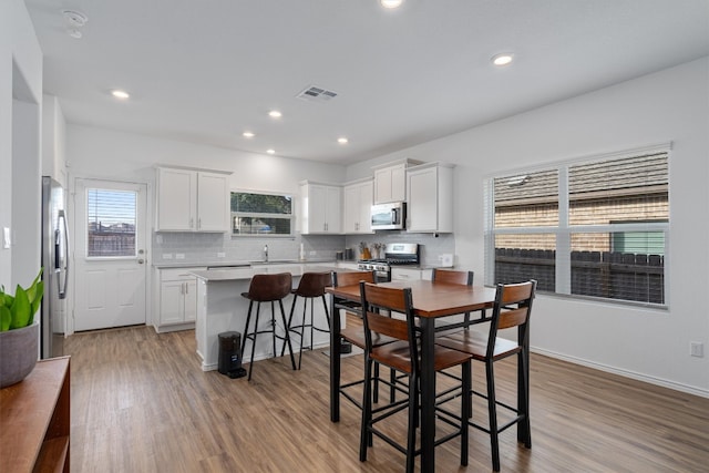 dining room featuring sink and light hardwood / wood-style floors