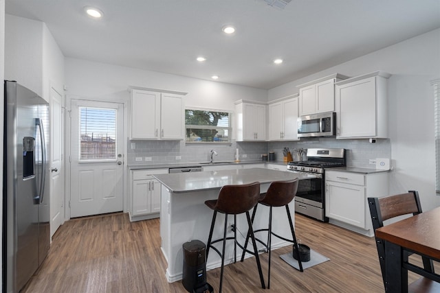 kitchen featuring stainless steel appliances, white cabinetry, plenty of natural light, and sink