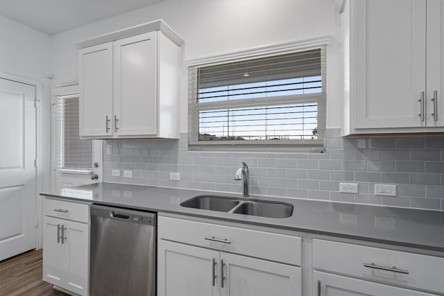 kitchen with tasteful backsplash, stainless steel dishwasher, sink, white cabinets, and dark hardwood / wood-style floors