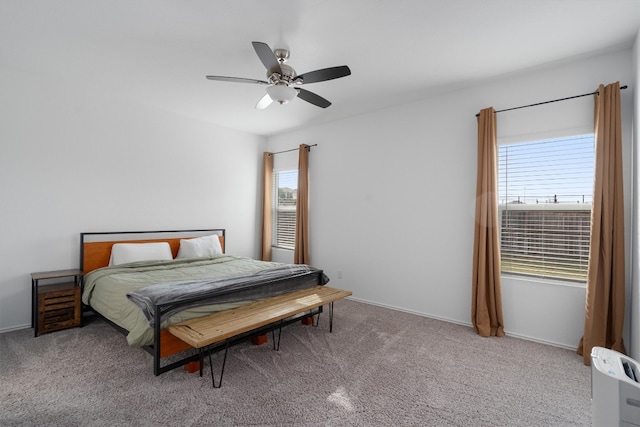 carpeted bedroom featuring multiple windows and ceiling fan