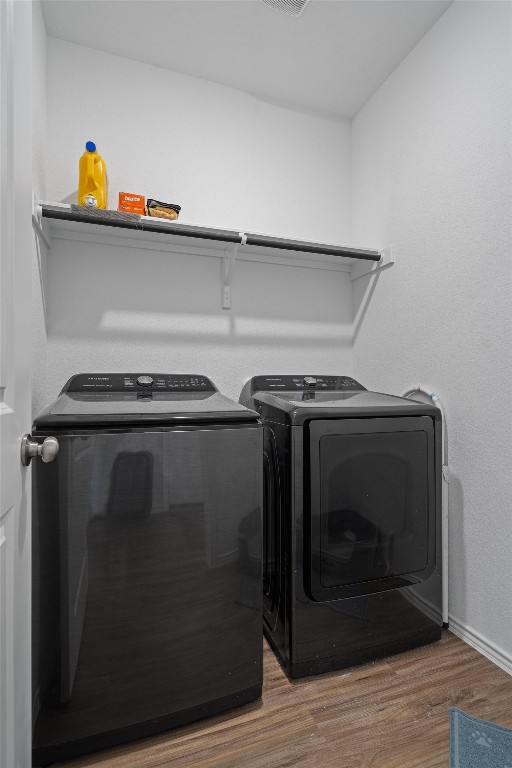 laundry area with hardwood / wood-style floors and washer and dryer