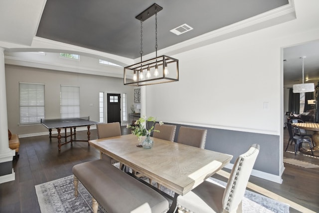 dining space featuring crown molding and dark wood-type flooring