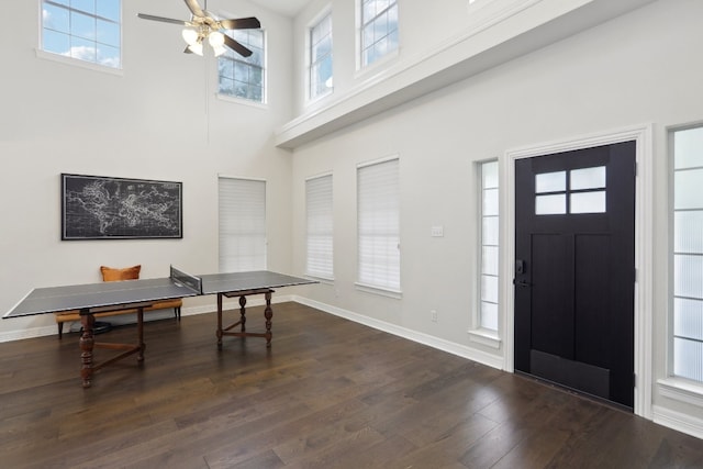 foyer with a towering ceiling, dark hardwood / wood-style flooring, and ceiling fan