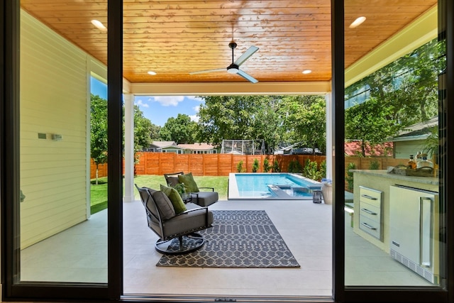 view of patio / terrace with ceiling fan and a fenced in pool