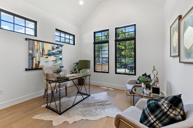 office area featuring high vaulted ceiling and light hardwood / wood-style flooring