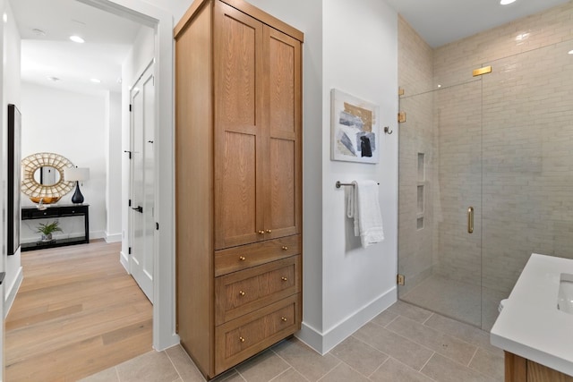 bathroom with an enclosed shower and tile patterned flooring