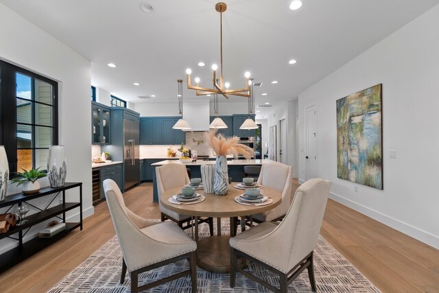 dining space featuring a notable chandelier, light hardwood / wood-style floors, and wine cooler