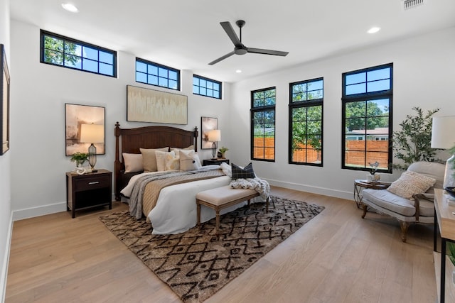 bedroom featuring multiple windows, light wood-type flooring, and ceiling fan