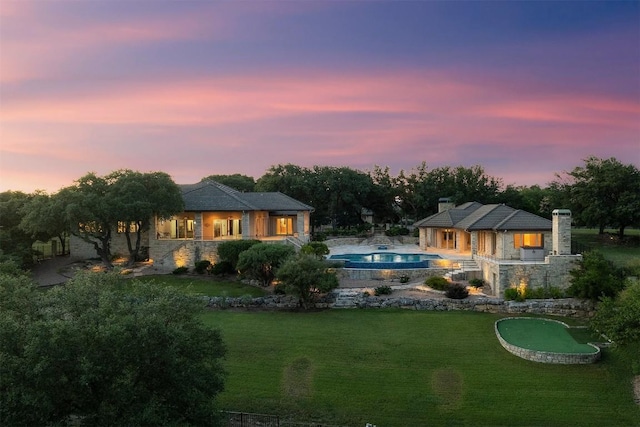 back house at dusk with a yard