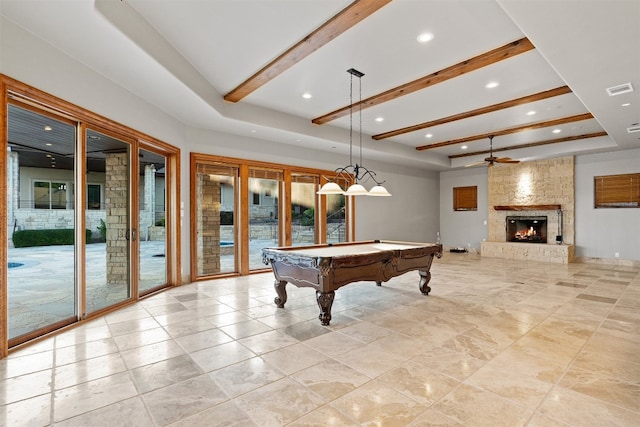 playroom featuring billiards, a large fireplace, a tray ceiling, ceiling fan, and beam ceiling