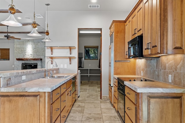 kitchen with a stone fireplace, pendant lighting, sink, backsplash, and ceiling fan