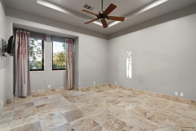 spare room featuring a tray ceiling and ceiling fan