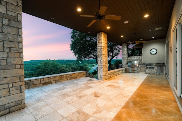 patio terrace at dusk featuring area for grilling and ceiling fan