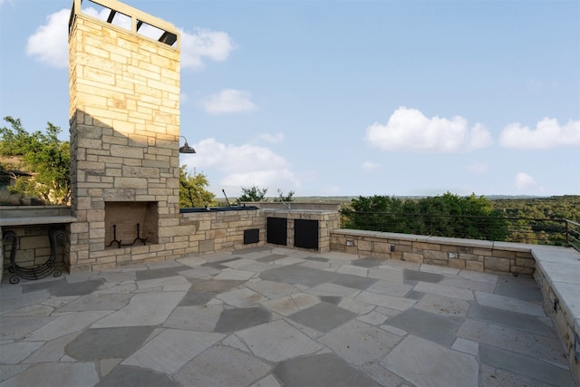 view of patio with an outdoor stone fireplace