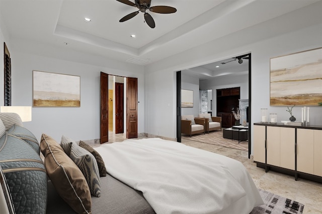 bedroom featuring a raised ceiling and ceiling fan