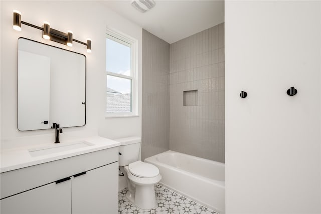 full bathroom with toilet, tiled shower / bath, vanity, and tile patterned floors