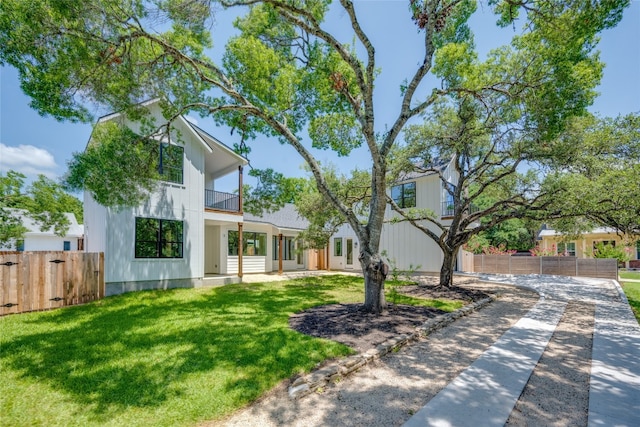 view of front facade featuring a balcony and a front lawn