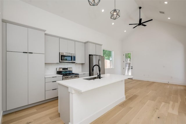 1928 Miles Ave Unit 2, Austin, TX 78745 - kitchen featuring appliances with stainless steel finishes, a sink, a kitchen island with sink, recessed lighting, and light wood-type flooring