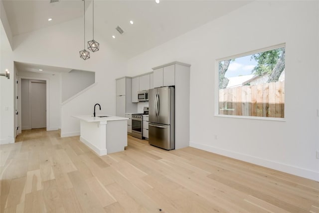 1928 Miles Ave Unit 2, Austin, TX 78745 - kitchen featuring stainless steel appliances, light countertops, light wood finished floors, baseboards, and high vaulted ceiling