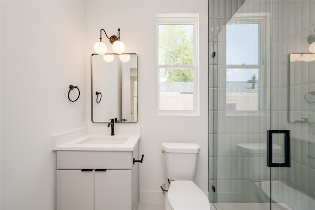 bathroom featuring a shower with shower door, toilet, and vanity