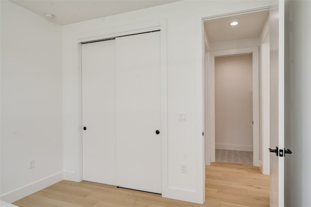 unfurnished bedroom featuring light hardwood / wood-style flooring and a closet