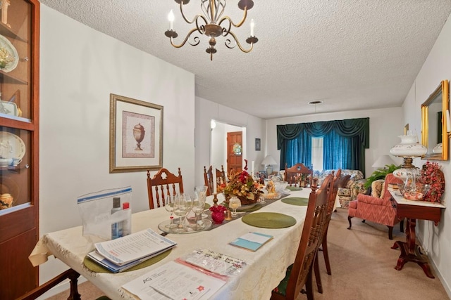 dining room with a textured ceiling, a notable chandelier, and light colored carpet