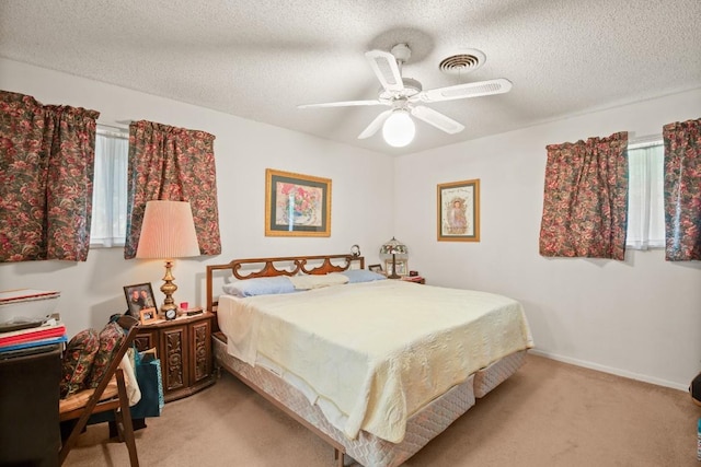 bedroom featuring a textured ceiling, ceiling fan, baseboards, and light colored carpet