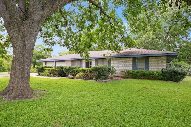 single story home with a garage, a front yard, and brick siding