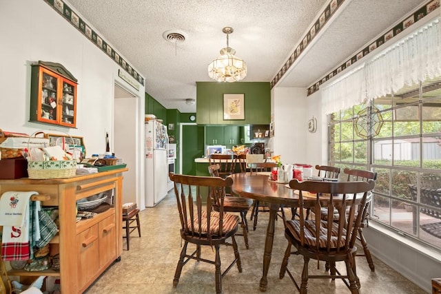 dining space with plenty of natural light, visible vents, a chandelier, and a textured ceiling