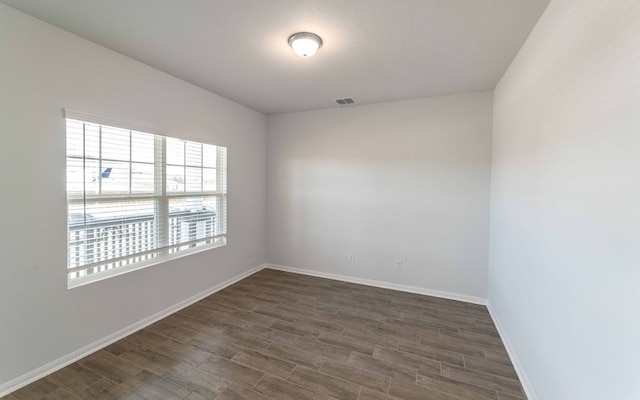 unfurnished room with dark wood-type flooring