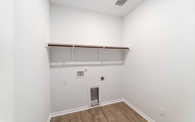 clothes washing area with hookup for a washing machine, gas dryer hookup, hardwood / wood-style floors, and hookup for an electric dryer