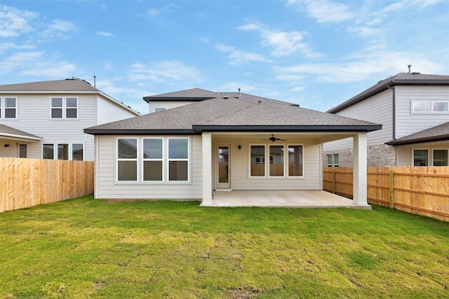 back of house featuring ceiling fan, a patio area, and a lawn