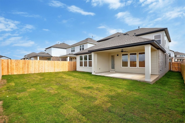 back of house featuring a lawn, ceiling fan, and a patio area