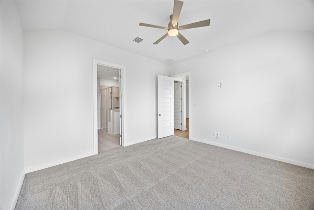 unfurnished bedroom with ceiling fan, ensuite bathroom, and light carpet