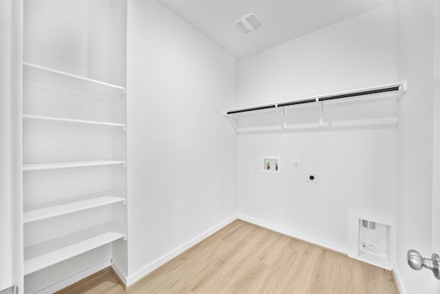 laundry room with hookup for a washing machine, gas dryer hookup, wood-type flooring, and hookup for an electric dryer