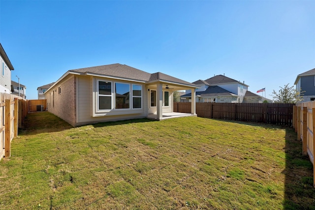 back of property with a lawn, a patio, and ceiling fan