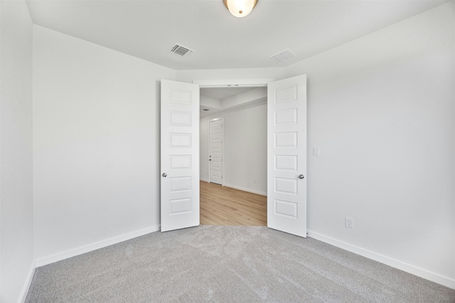 unfurnished bedroom with light carpet and a closet