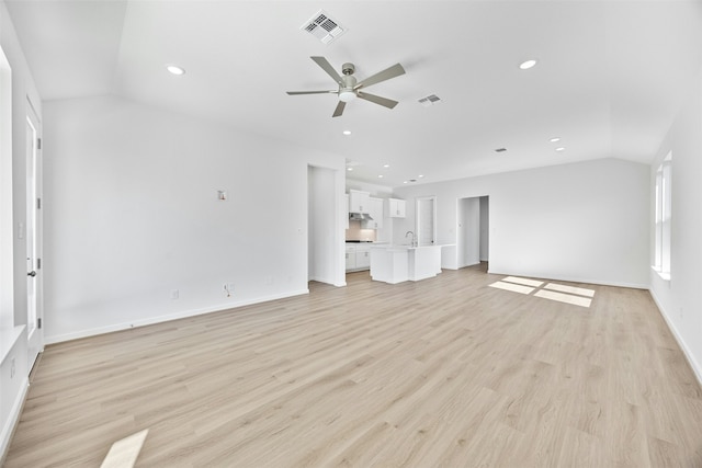 unfurnished living room featuring ceiling fan, sink, vaulted ceiling, and light hardwood / wood-style flooring