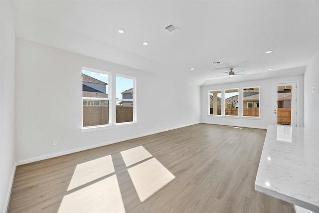 unfurnished living room featuring ceiling fan and light hardwood / wood-style floors