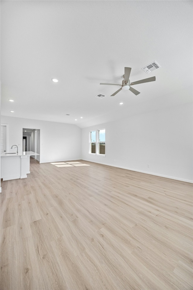 empty room with sink, light hardwood / wood-style floors, and ceiling fan