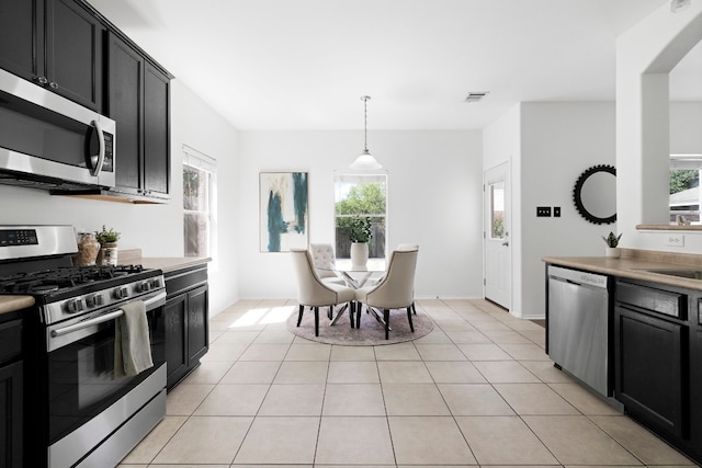 kitchen featuring stainless steel appliances, pendant lighting, and light tile patterned floors