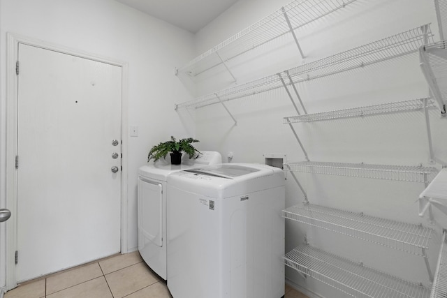 laundry area with light tile patterned flooring and washing machine and clothes dryer